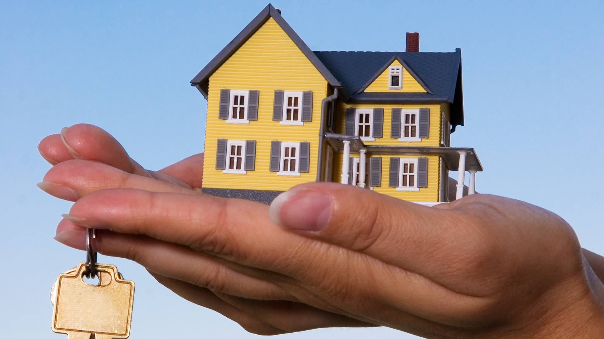Maison miniature dans une main 